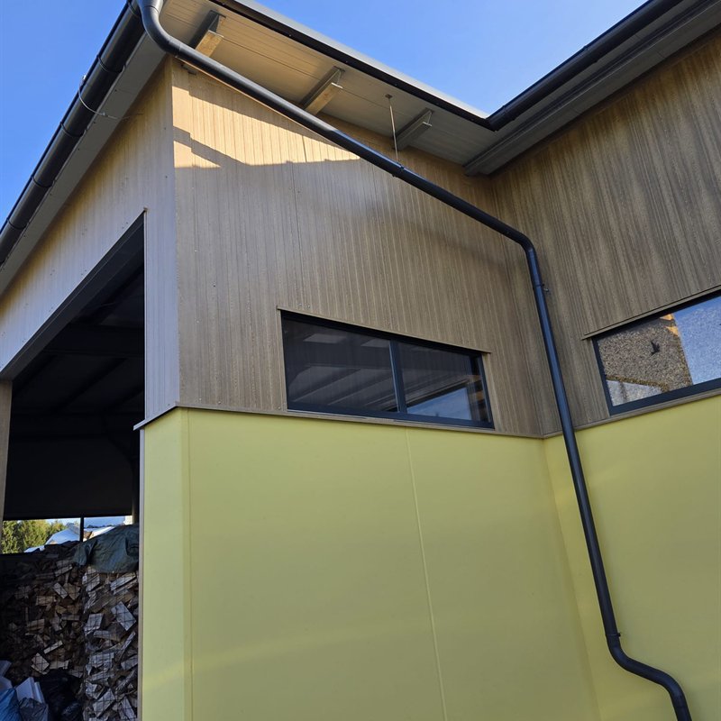 Gewerbebau mit farbigen Metallpaneelen und Holzverkleidung