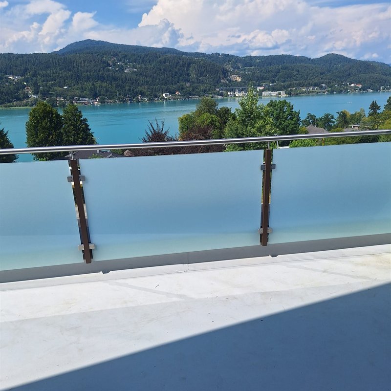 Glasgeländer auf einem Balkon mit Seeblick