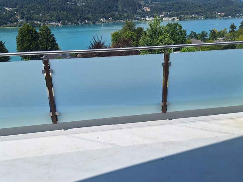 Glasgeländer auf einem Balkon mit Seeblick