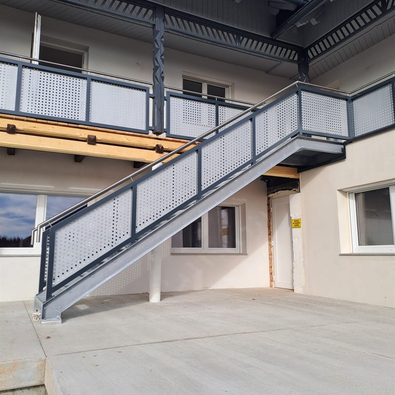 Außentreppe aus Stahl mit Lochblechgeländer an einem Wohnhaus